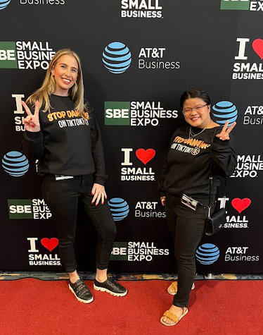 Two women, employees of SOAR Media, wearing T-shirts that read "Stop Dancing on TikTok"